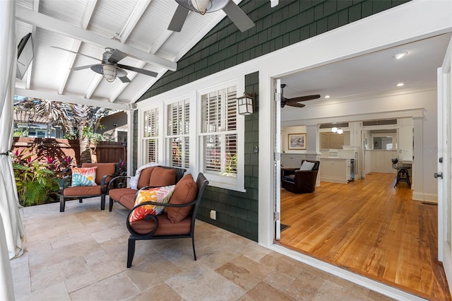 sunroom with lofted ceiling with beams and ceiling fan