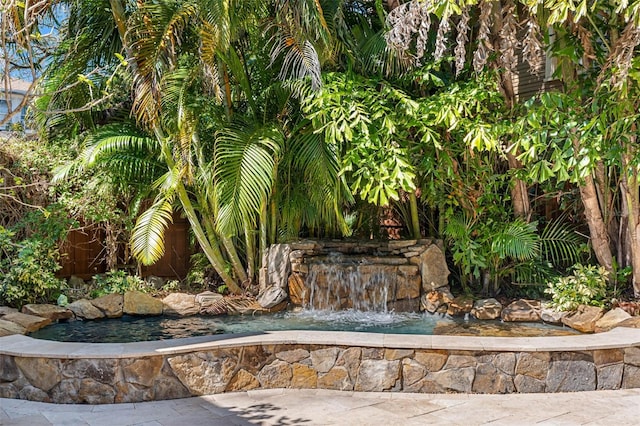 surrounding community featuring a garden pond and fence