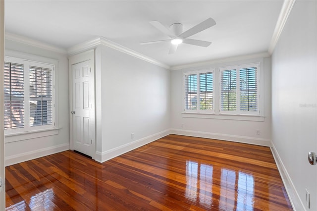 unfurnished room featuring baseboards, wood finished floors, and ornamental molding