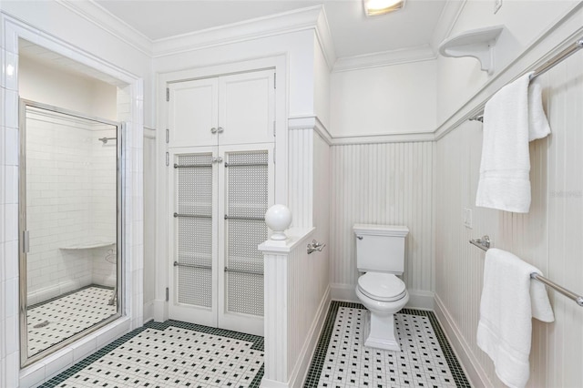 full bath with baseboards, toilet, ornamental molding, and a shower stall