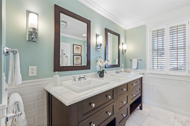 bathroom with a sink, wainscoting, tile patterned floors, and ornamental molding