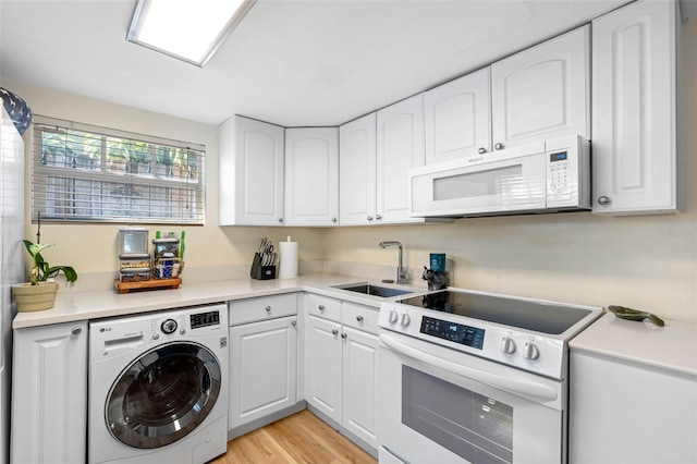 interior space featuring a sink, white appliances, washer / dryer, and white cabinets