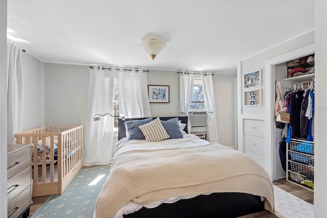 bedroom with a closet, wood finished floors, and cooling unit