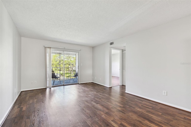 spare room with visible vents, a textured ceiling, baseboards, and wood finished floors