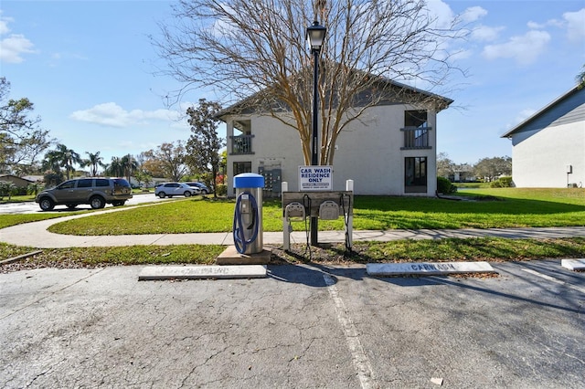 exterior space with uncovered parking and a yard