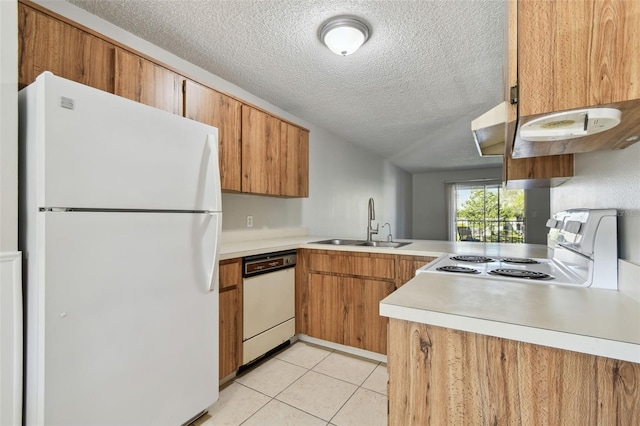 kitchen with white appliances, light tile patterned floors, brown cabinetry, light countertops, and a sink