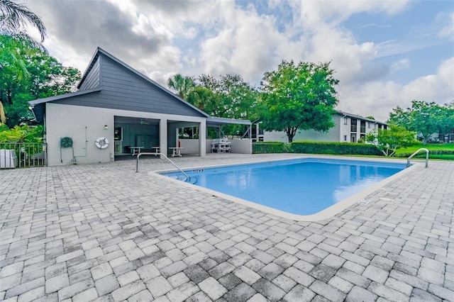 outdoor pool with a patio and fence