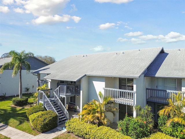 view of front of house with a shingled roof and stairway