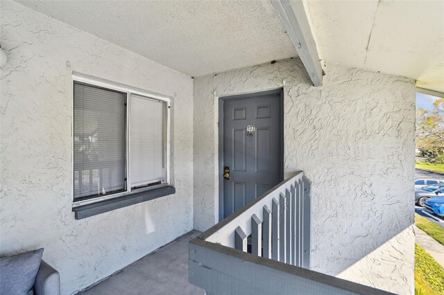 doorway to property featuring stucco siding