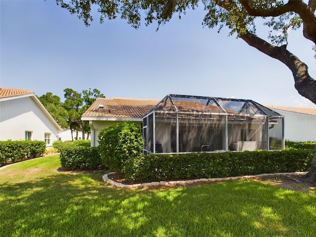 rear view of property with a yard and a tiled roof