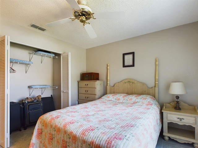 carpeted bedroom featuring ceiling fan, a textured ceiling, visible vents, and a closet