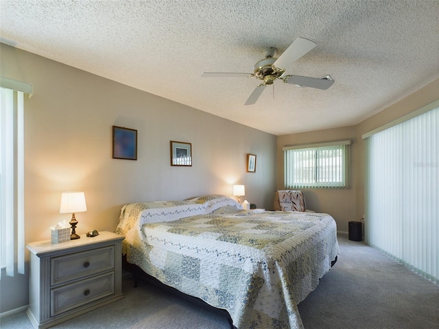 bedroom with ceiling fan, baseboards, a textured ceiling, and light colored carpet