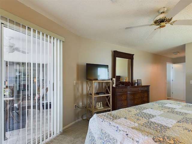 carpeted bedroom with ceiling fan, a textured ceiling, and baseboards