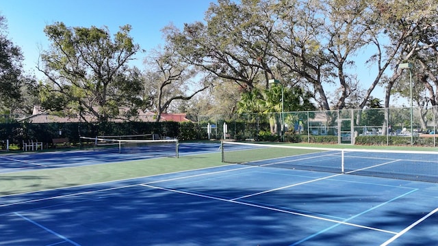 view of tennis court featuring fence