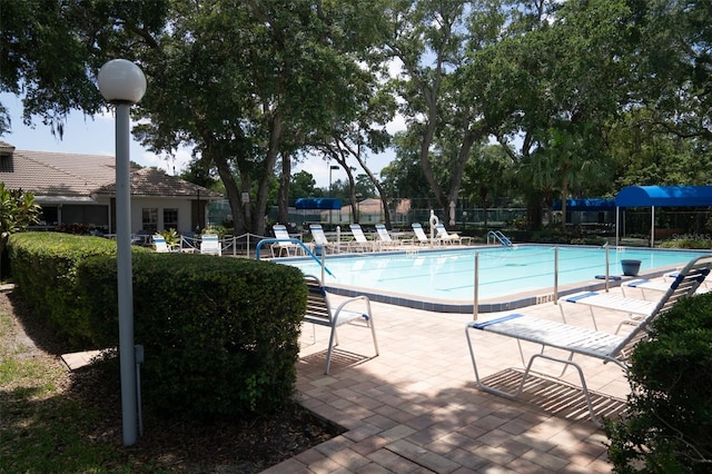 pool with a patio area and fence