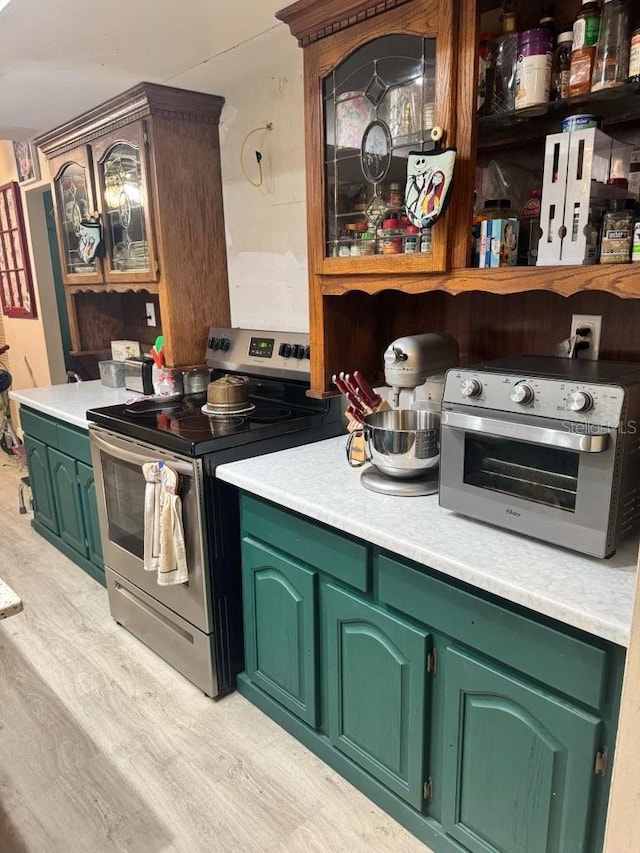 kitchen featuring light wood-type flooring, a toaster, light countertops, and stainless steel range with electric cooktop