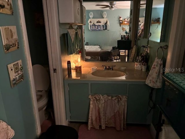 bathroom with vanity, toilet, and a ceiling fan