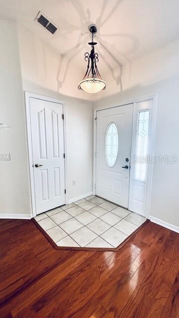 entrance foyer featuring baseboards, visible vents, and light wood finished floors