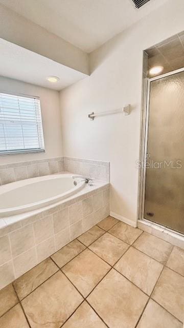 bathroom featuring a stall shower, a bath, and tile patterned floors