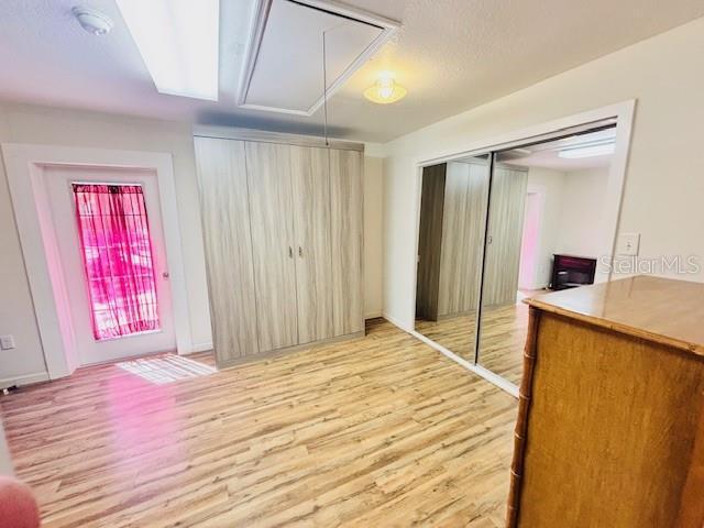 interior space with attic access, a closet, and wood finished floors