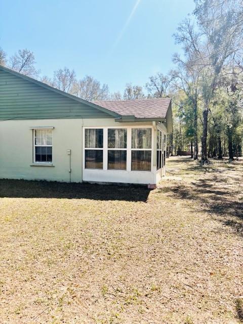 view of side of home featuring a sunroom