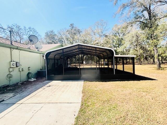 view of parking featuring a detached carport and concrete driveway