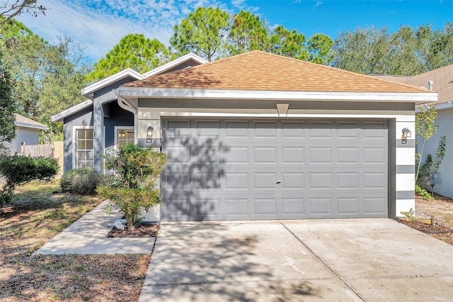 single story home featuring driveway, a shingled roof, and stucco siding