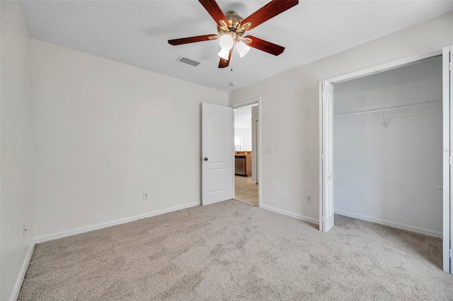 unfurnished bedroom with light colored carpet, a ceiling fan, baseboards, visible vents, and a closet