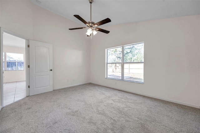 spare room with light carpet, baseboards, a ceiling fan, and light tile patterned flooring