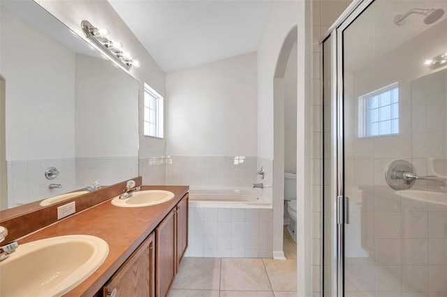 full bathroom featuring toilet, a garden tub, a sink, and tile patterned floors