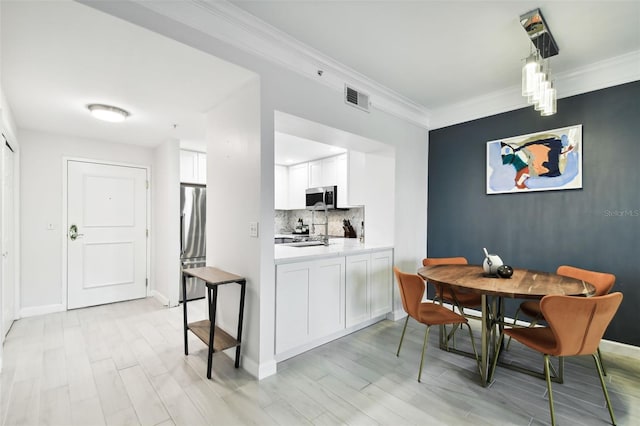 kitchen featuring visible vents, light countertops, white cabinets, appliances with stainless steel finishes, and backsplash