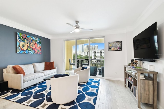 living area featuring a ceiling fan, crown molding, light wood-style floors, and baseboards