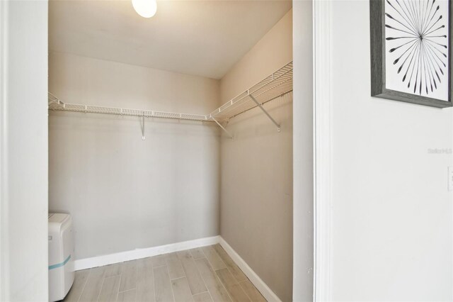 walk in closet with wood finished floors and washer and clothes dryer