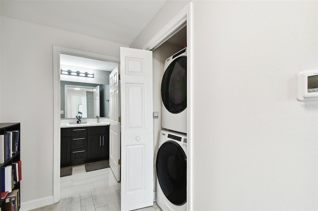 laundry area with stacked washer / dryer, laundry area, and a sink