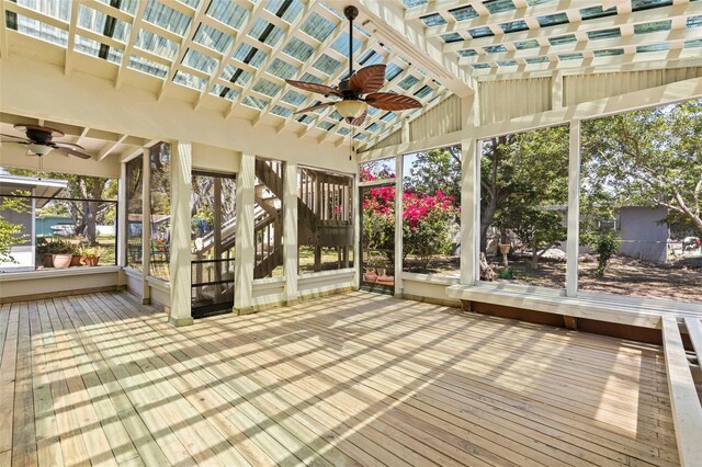 unfurnished sunroom with ceiling fan