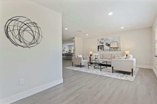 living room with recessed lighting, wood finished floors, and baseboards