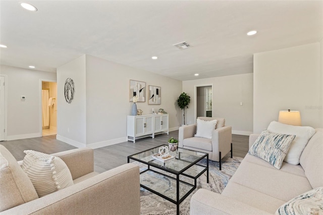 living area featuring recessed lighting, wood finished floors, visible vents, and baseboards