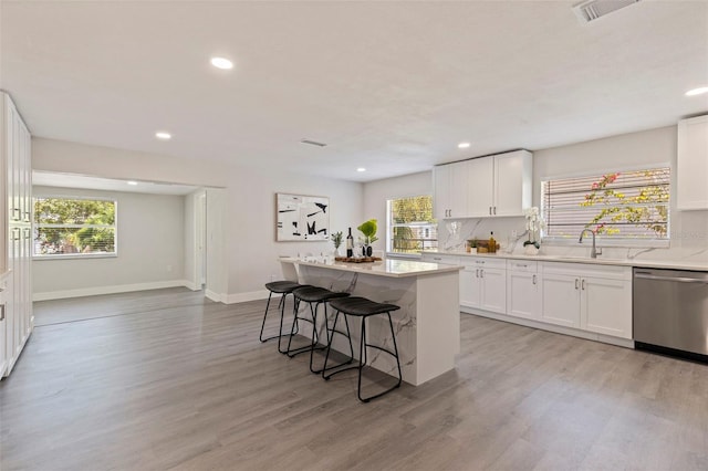 kitchen featuring dishwasher, a healthy amount of sunlight, visible vents, and light wood finished floors