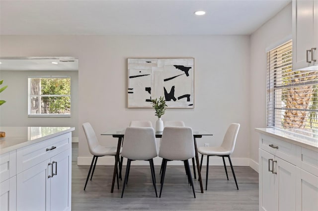 dining area featuring baseboards, light wood finished floors, and recessed lighting