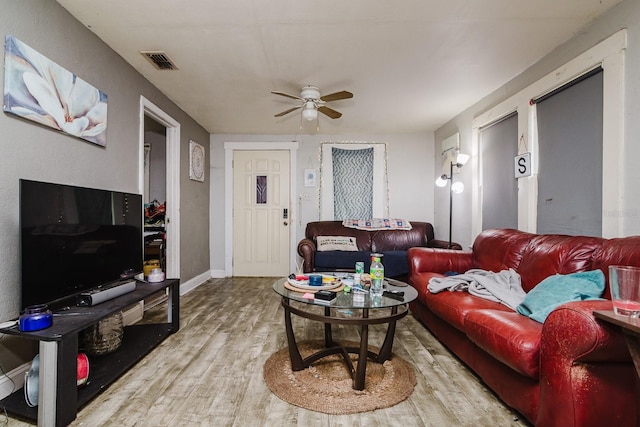 living room with baseboards, ceiling fan, visible vents, and wood finished floors