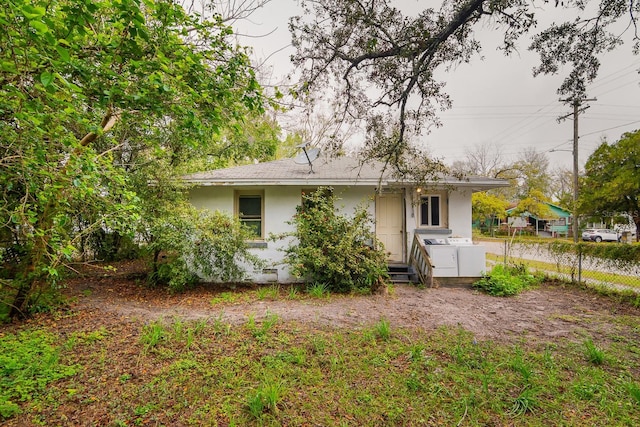 rear view of house with washer and dryer and stucco siding