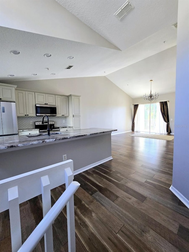 kitchen featuring a notable chandelier, dark wood-style flooring, visible vents, vaulted ceiling, and appliances with stainless steel finishes