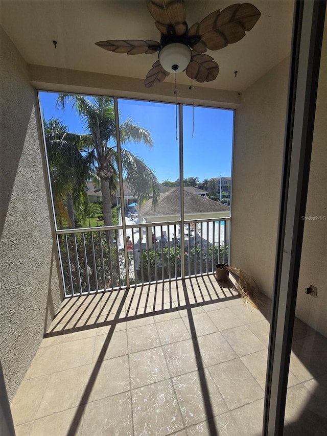 unfurnished sunroom with a ceiling fan