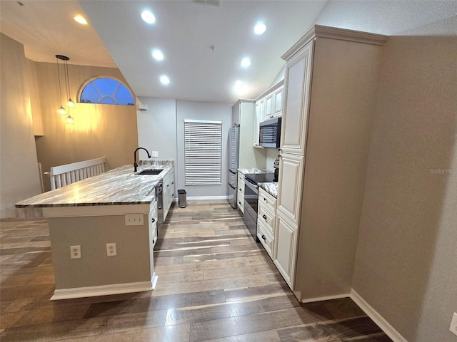 kitchen featuring stainless steel appliances, recessed lighting, a sink, light wood-type flooring, and a peninsula