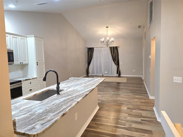 kitchen featuring a notable chandelier, stainless steel appliances, wood finished floors, a sink, and white cabinets