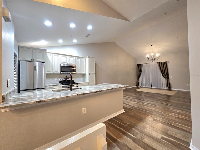 kitchen with dark wood-style flooring, stainless steel appliances, lofted ceiling, a sink, and light stone countertops