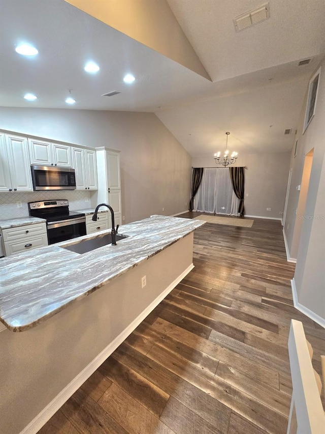 kitchen featuring lofted ceiling, visible vents, appliances with stainless steel finishes, a sink, and a chandelier