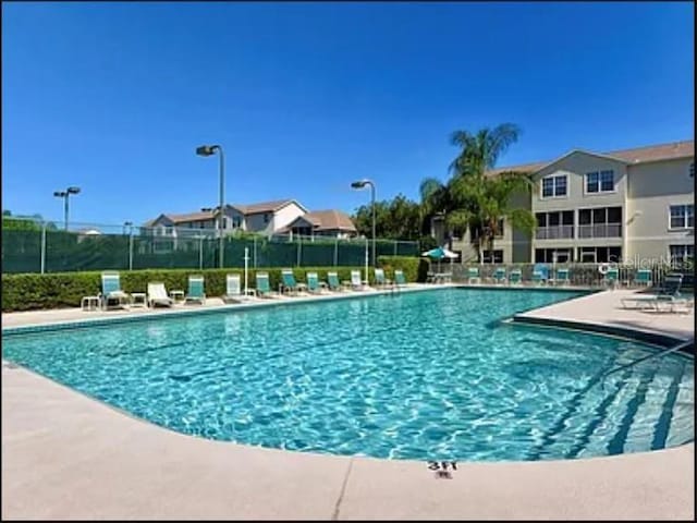 community pool featuring a patio and fence