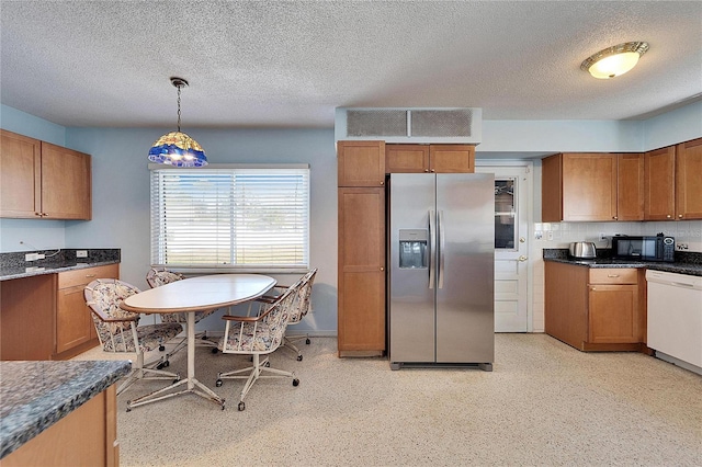 kitchen featuring black microwave, white dishwasher, stainless steel fridge, and brown cabinets