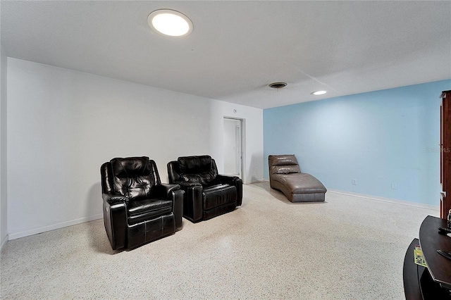 sitting room featuring baseboards, visible vents, a textured ceiling, and speckled floor